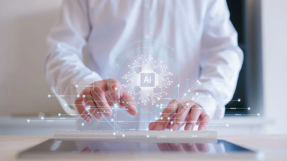 Eine Person in einem weißen Hemd benutzt ein Tablet mit einer digitalen Abbildung von Schaltkreisen und einem eingeblendeten "AI"-Symbol, das für KI-Technologie und digitale Datenbasis steht.