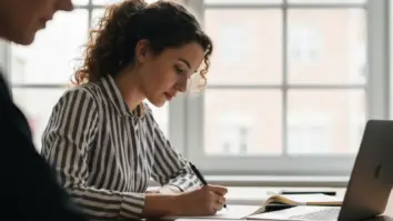 Junge Gründerin erstellt Businessplan am Schreibtisch