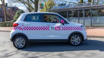 YouTaxi Elektroauto mit magentafarbenem Carsharing-Design an Bushaltestelle in Ahaus