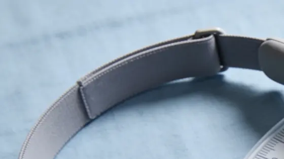Ein unbeschriftetes Kopfband liegt neben konzentrischen Reichweitenringen, während sich ein roter Keil einem geschützten Einstellregler nähert.