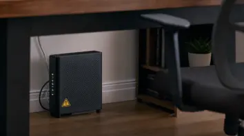 Heimrouter unter dem Schreibtisch mit dezentem Warnhinweis