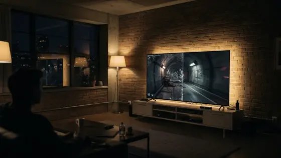 Eine Person prüft Leistungsoptionen eines PS5-Spiels im Wohnzimmer.